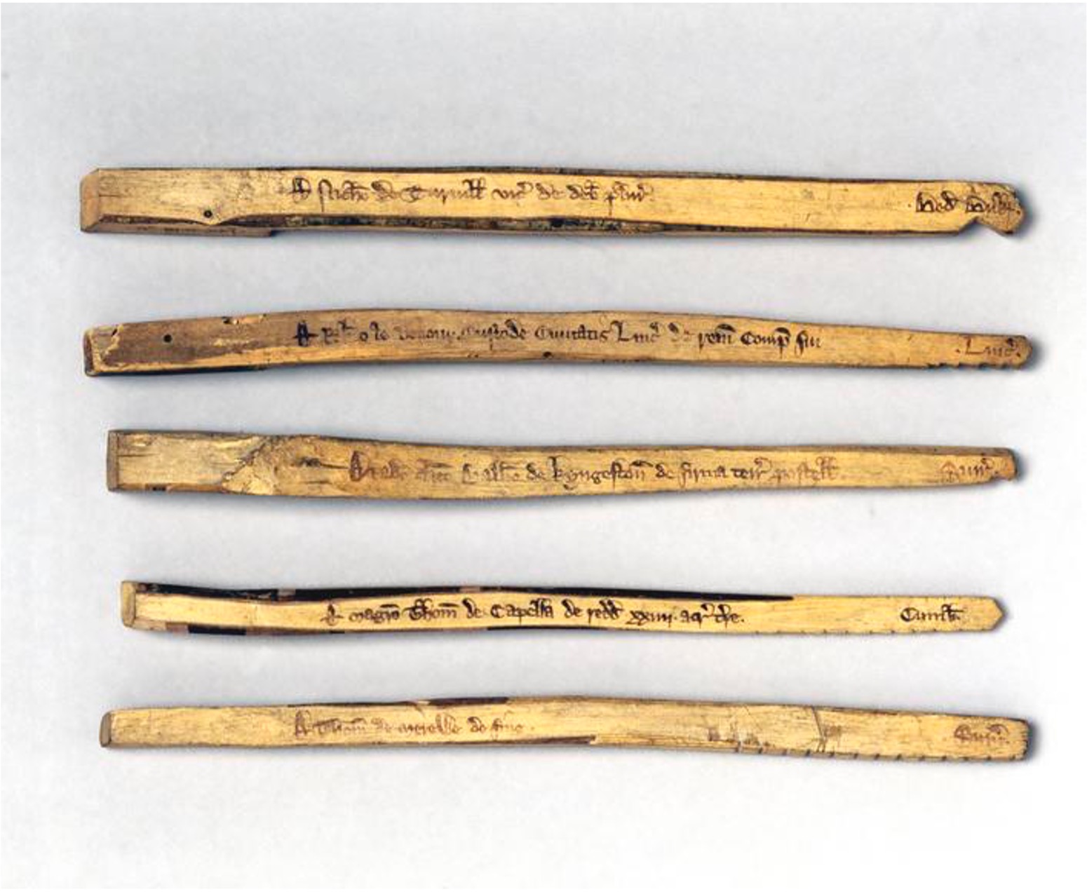 A group of wooden sticks with writing on them Description automatically generated